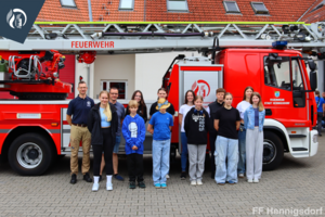 Bild vergr&ouml;&szlig;ern: Gruppenbild der Jugendfeuerwehr an Drehleiter vor Abfahrt