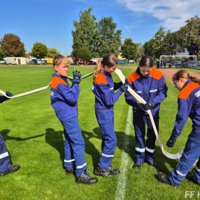 Bild vergr&ouml;&szlig;ern: Teamarbeit der Jugendfeuerwehr mit Feuerwehrschlauch