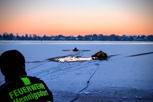 Bild vergr&ouml;&szlig;ern: Zwei Feuerwehrleute sind bei einem Probeeinsatz auf dem Eis zu sehen. Der einer zieht mit einem Seil während ein zweiter einen auf einem Board befestigtes Opfer aus einem Eisloch zieht. Im Vordergrund ist ein Feuerwehrmann mit reflektierender Jacke und der Aufschrift "FEUERWEHR Hennigsdorf" zu sehen.