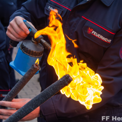 Bild vergr&ouml;&szlig;ern: Entzünden einer Fackel durch eine Feuerwehrkameradin