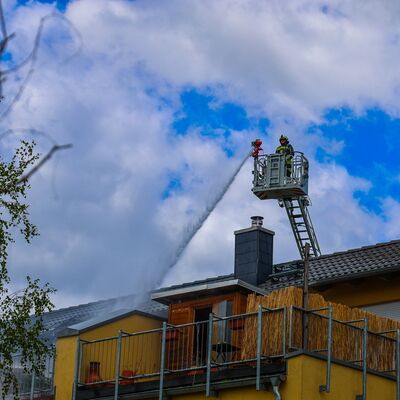 Bild vergr&ouml;&szlig;ern: Korb der Drehleiter mit Eunsatzkraft beim Löschen des Daches