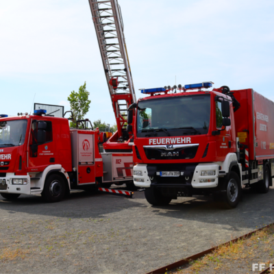 Bild vergr&ouml;&szlig;ern: Drehleiter und Gerätewagen auf dem Sportplatz beim Feuerwehr und Bahnenlauf